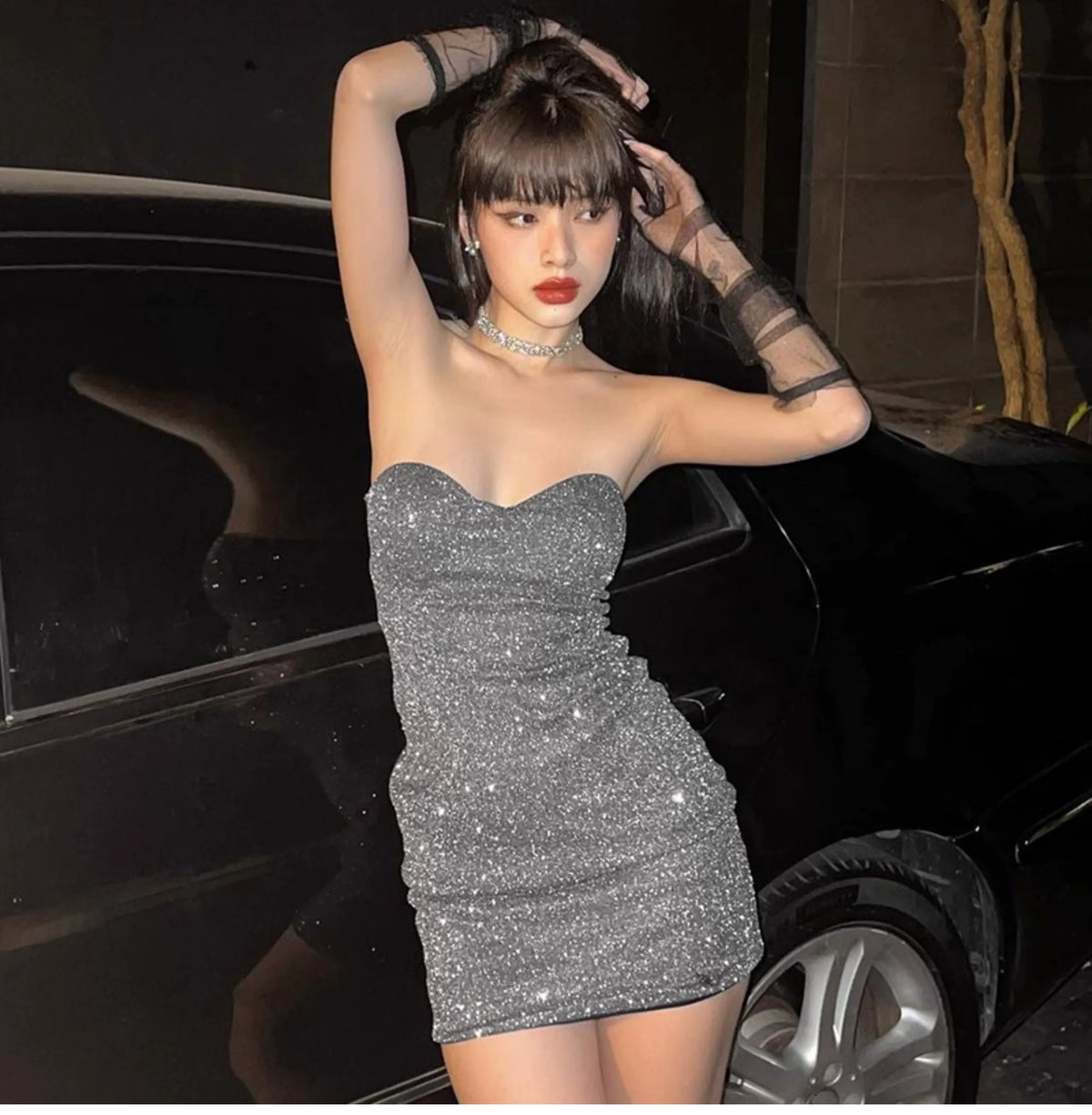 A feminine one-shoulder shiny wrap-around bustier dress in solid color with pleated high waistline, creating an illusion of slimming and a curvy figure. Short skirt.